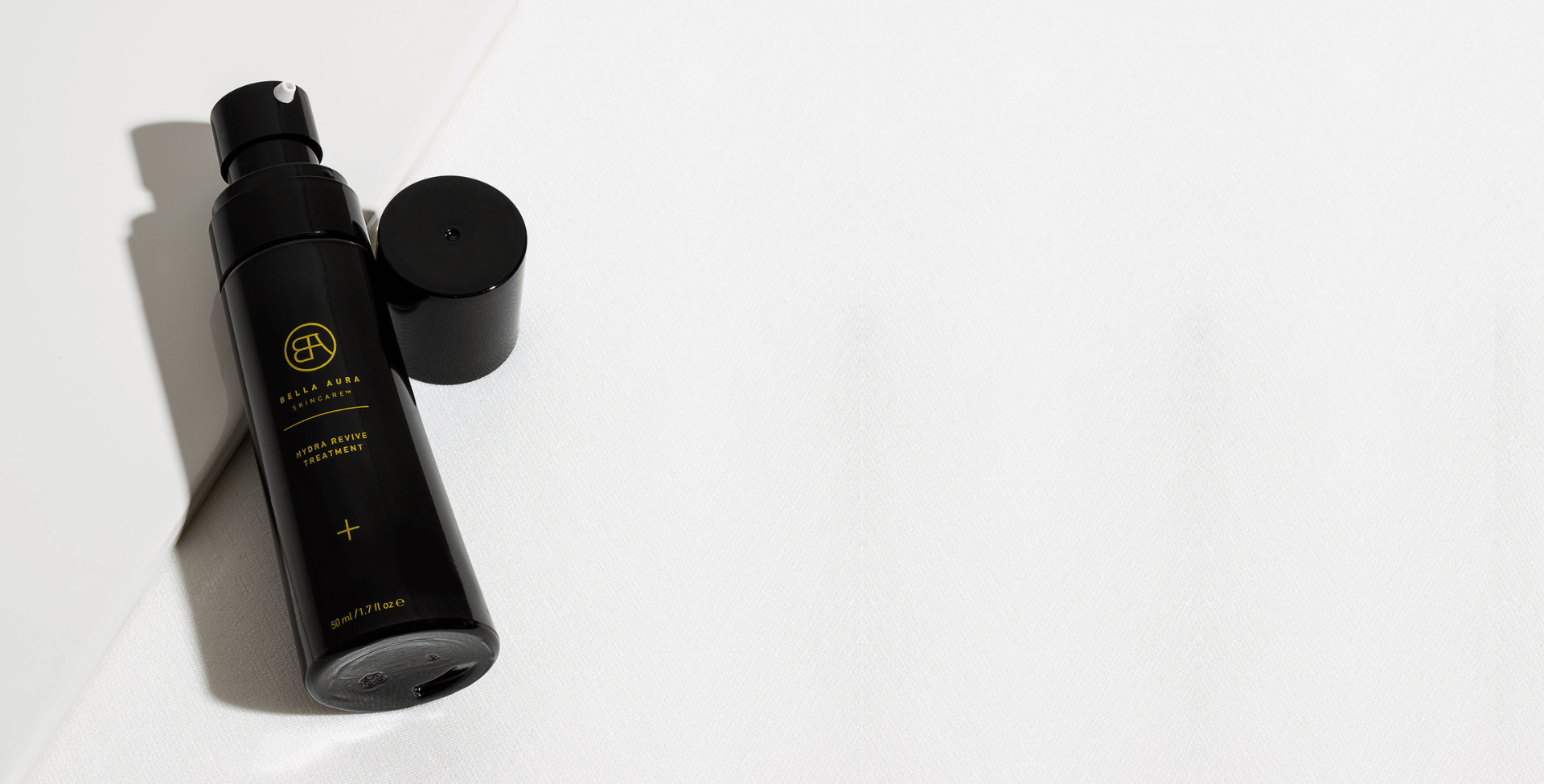 Black glass bottle bella aura hydra revive treatment with a cap on a white background