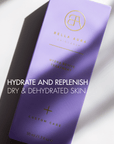 Purple skincare product packaging with Bella Aura branding on a light background