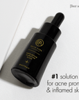 Black bella aura skincare dropper bottle with gold text on a white background