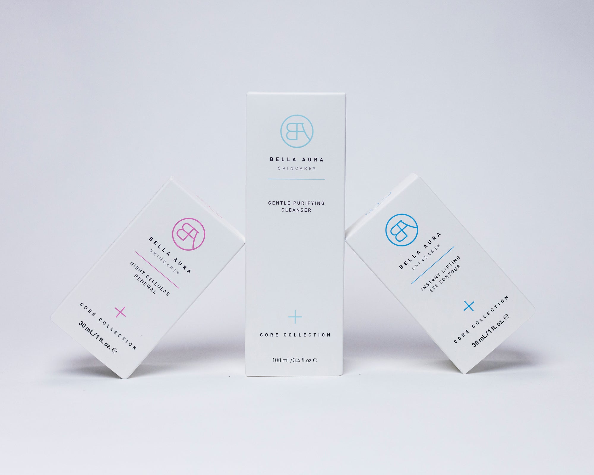 Three skincare product boxes from Bella Aura on a light gray background