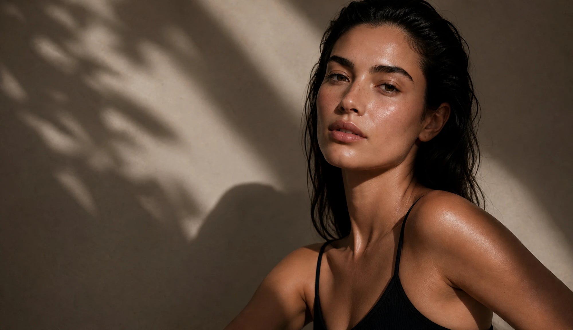 Woman with wet hair against a textured wall